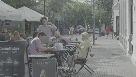 People sitting at an open-air café along the street in Buenos Aires, Argentina Video stock 345137642