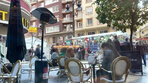 People sitting in an outdoor cafe during Fallas festival in Valencia Stock Footage 333033181