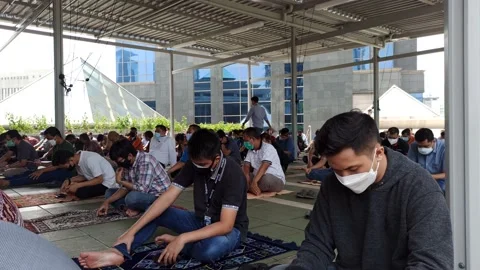 PEOPLE SITTING WITH PSYCAL DISTANCING AT MOSQUE BEFORE JUMAAT PRAYER Stock Footage 159541701