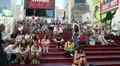 People sitting on the red stepped seating in Times Square HD Footage