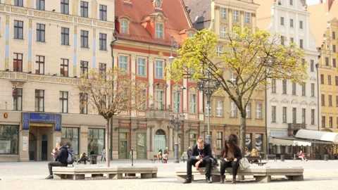People sitting using Mobile Phones on a Bench on City Center of Wroclaw, Poland Stock Footage 152765059
