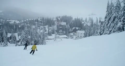 People skiing on a snowy slope on a cloudy day Stock Footage 264985681