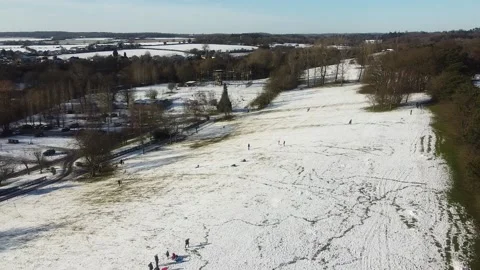 People sledding down a hill in winter aerial snowy woodland landscape with Stock Footage 166822401