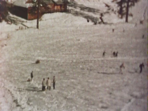 People sledding down a snowy hill - vintage 8mm Stock Footage 79270595