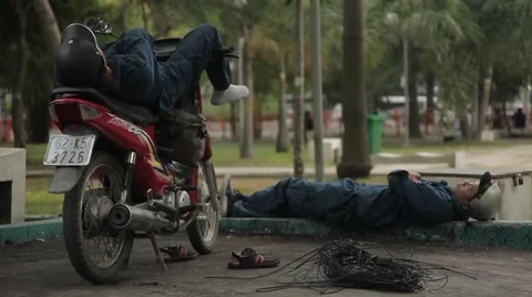 People sleep during the day, lying on a motorbike on a noisy street. Stock Footage 42884440