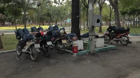 People sleep during the day, lying on a motorbike on a noisy street. Stock Footage 42884464