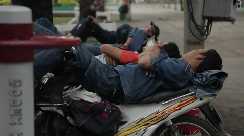 People sleep during the day, lying on a motorbike on a noisy street. Stock Footage 42884506