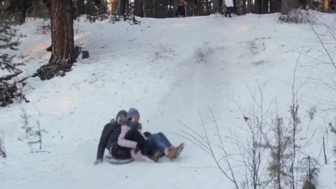 People slide down the hill on flat sledges, winter activity, fun of sledding Video stock 208324469
