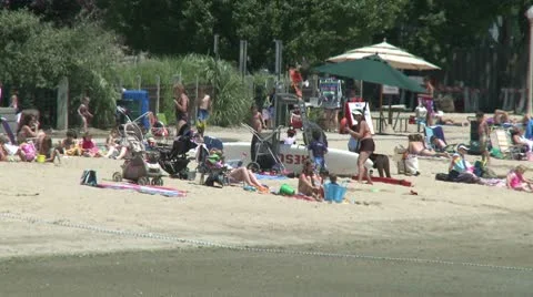 People at small beach with beach umbrellas Stock Footage 8981871