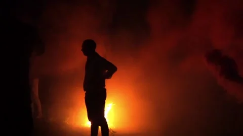 People in the smoke next to the fire Stock Footage 163726225