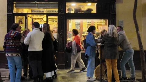 People socializing at tapas bars outside in Seville at night Stock Footage 296350780