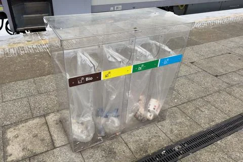 People Sort Trash at a Bus Stop Using Bins for Bio Plastic and Other Materi.. Stock Photos