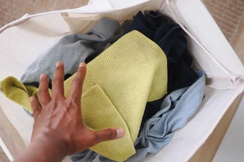 People sorting laundry in a basket at home during the day Stock Photos