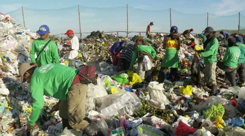 People sorting through trash in a open garbage dumb or landfill Stock Footage