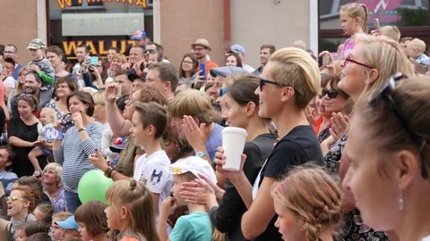 People spectators crowd clap and applaud enjoy circus street busker performance Stock Footage 78733150