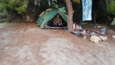 People spend time camping in forest by seacoast on sunny day Video stock 103836157