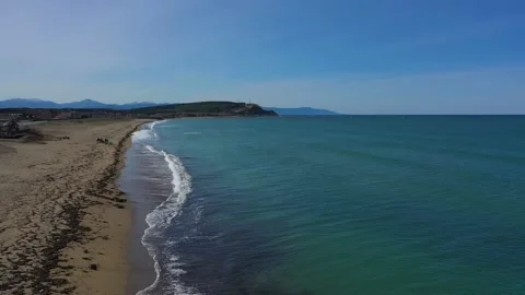 People spend time on wide beach near tranquil azure ocean Видео 148010844