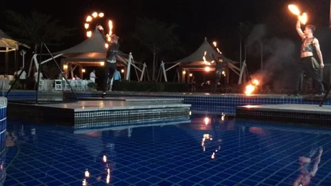 People spin chains of fire at night by the water Video stock 146936420