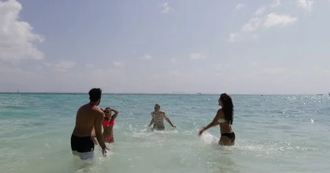 People Splashing In Water Having Fun On Beach, Cheerful Men And Women Group Stock Footage
