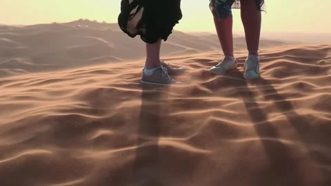 People stand on a desert sand dune in Dubai. The wind blows away the sand Stock Footage 278864662