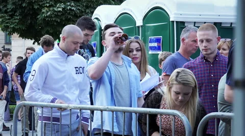 People stand in queue outside the concert arena Stock Footage 54763341