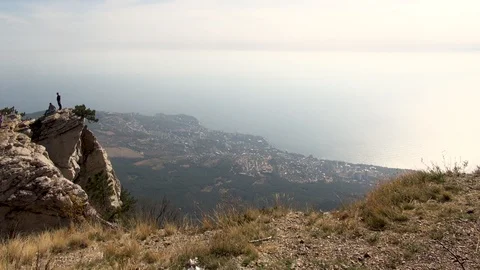 People stand on sheer cliff of Mount Ai-Petri on edge of bottomless abyss Stock Footage 106774986