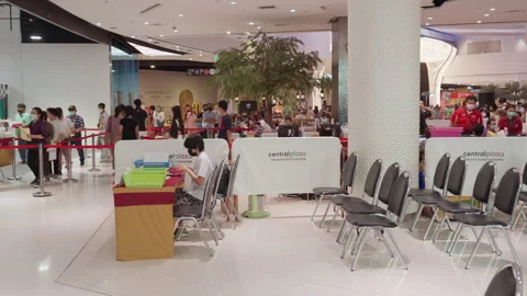 People Stand &amp; Wait In Line For Covid Flu Vaccination At Asia Indoor Clinic Stock Footage 256059850