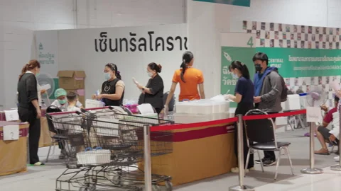 People Stand &amp; Wait In Line For Covid Flu Vaccination At Asia Indoor Clinic Stock Footage 256060351