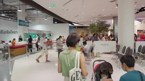 People Stand &amp; Wait In Line For Covid Flu Vaccination At Asia Indoor Clinic Stock Footage 256060389