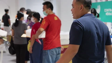 People Stand &amp; Wait In Line For Covid Flu Vaccination At Asia Indoor Clinic Stockbeeldmateriaal 256097849