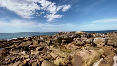 People standing and preparing to jump into the sea at the far side of sea rocks Stock Footage 168920985