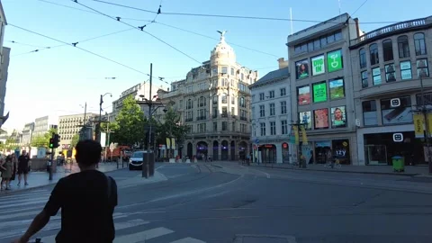 People standing at a crossing while cyclists pass by Stock Footage 228944630