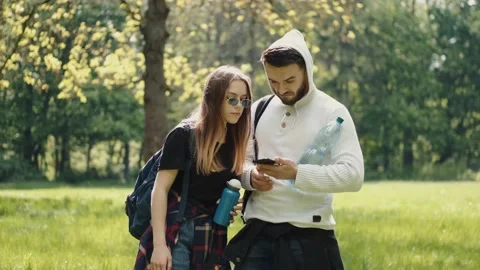 People standing in a forest with map in a phone Stock Footage 136020083