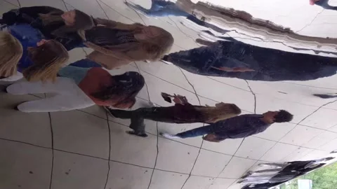 People standing inside Chicago's "Bean" sculpture looking at their reflections 库存影片 231455877