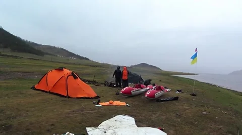 People Standing in Middle of a Small Camp on Bank of Mountain Lake Stock Footage 61178475