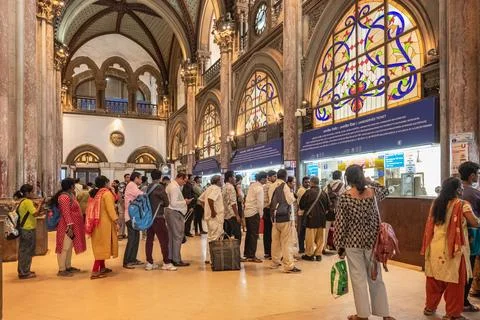 People standing in a queue to buy train tickets inside the Chhatrapati Shivaj Stock Photos