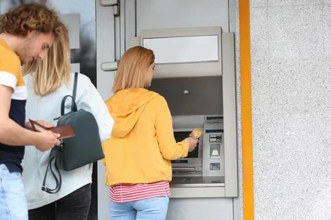 People standing in queue to cash machine outdoors Stock Photos