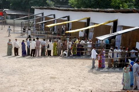 People standing in queue to cast their vote outside a polling booth during... Stock Photos