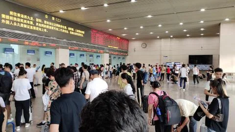 People standing in queue at train ticket booking counter Stock Photos