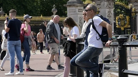 People standing resting, drinking coffee by Buckingham Palace Stock Footage 96715430
