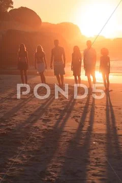 People standing in row in front of the sunset Stock Photos
