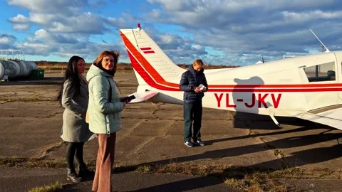 People standing by small aircraft as camera pans to reveal plane’s front Stock Footage 326281774