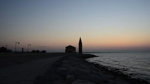 People stroll at dawn on the seafront of Caorle Stock Footage 219431159