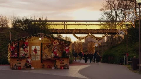 People stroll through a park decorated for Christmas during the evening Stock Footage 315225836