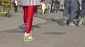 People strolling down street, focus on woman in bright red leggings, slow motion HD Footage