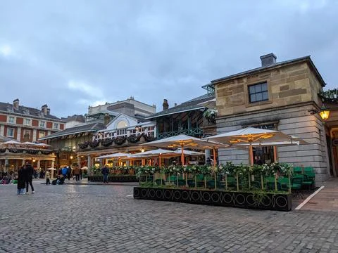 People strolling through the charming cobbled piazza of Londons historic Covent Stock Photos