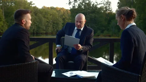 People in suits sit at a table and discuss something. Stock Footage 118378239
