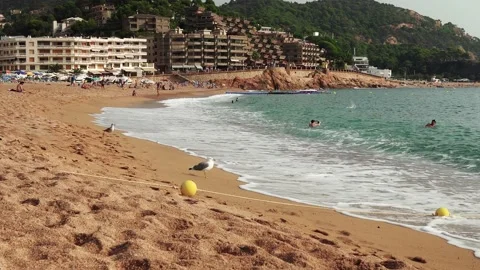 People sunbathe on the beach of Tossa de Mar Stock Footage 171543523