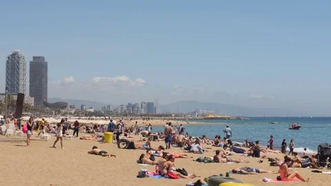 People Sunbathing & Relaxing in Summer Sun at Barceloneta Beach, Barcelona Stock Footage