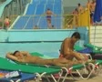 People on sunloungers with waterslide in background SD Footage